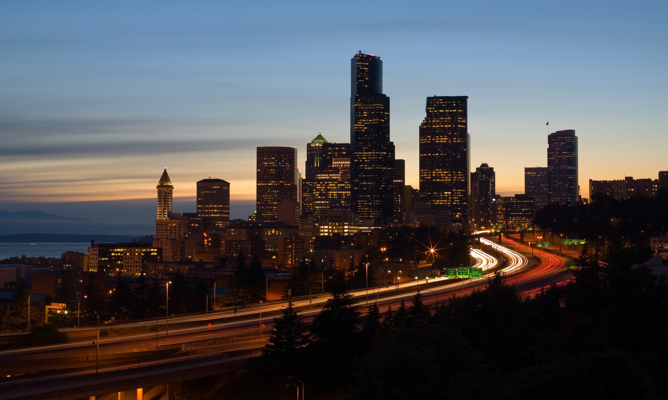 The Seattle skyline at dusk from Interstate 5, with Puget Sound to the west.